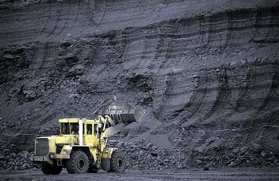Kazakhstan coal industry - Ekibastuz open pit coal mine truck in front of a wall of coal photo