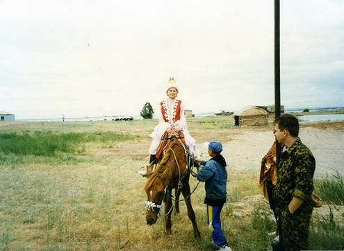 Kazakhstan people - Girl riding a horse in traditional dressing photo